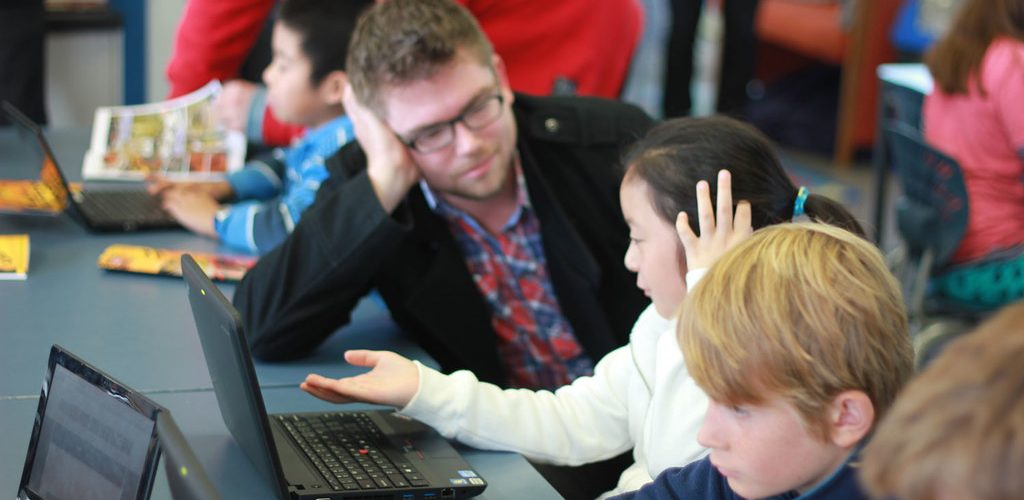 Teacher with pupil at laptop