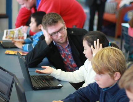 Teacher with pupil at laptop