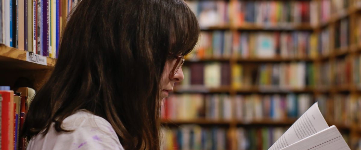 Young woman reads book in library